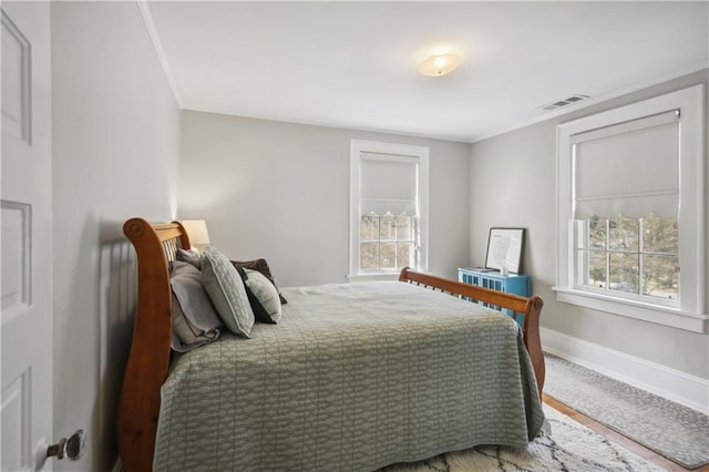 bedroom featuring multiple windows and crown molding