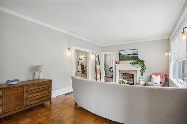 living room featuring light parquet flooring, a premium fireplace, and crown molding