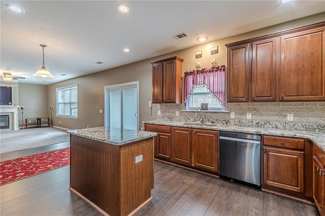 kitchen with dark wood finished floors, a kitchen island, open floor plan, stainless steel dishwasher, and a sink