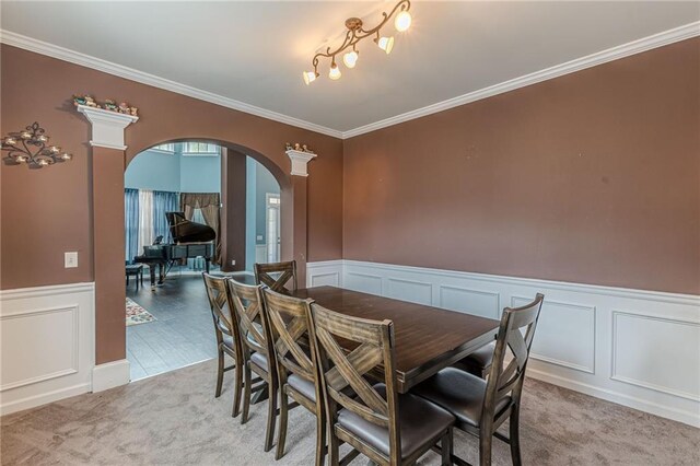 carpeted dining area featuring crown molding