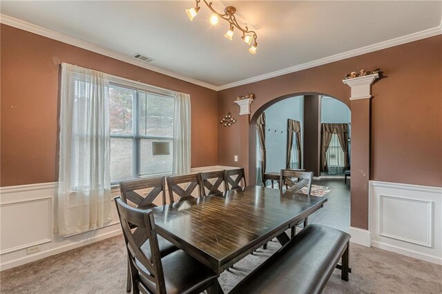 carpeted dining area featuring ornamental molding