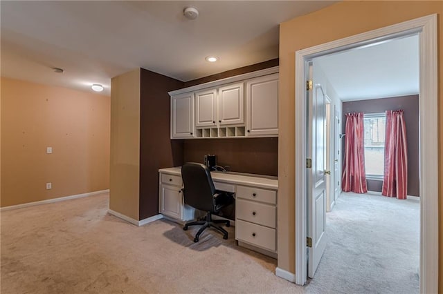 carpeted office space with built in desk