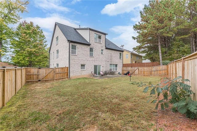 rear view of property featuring a fenced backyard and a yard