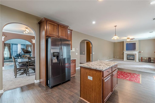 kitchen featuring ceiling fan, stainless steel fridge, dark hardwood / wood-style flooring, pendant lighting, and a kitchen island