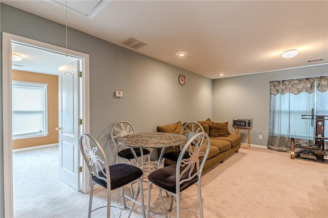 dining area featuring carpet, visible vents, and attic access