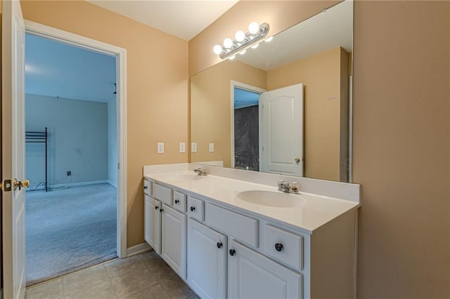 full bath featuring double vanity, tile patterned flooring, baseboards, and a sink