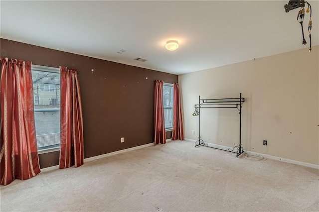 carpeted empty room with visible vents and baseboards