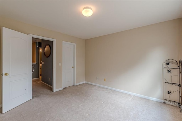 unfurnished bedroom featuring light carpet and baseboards