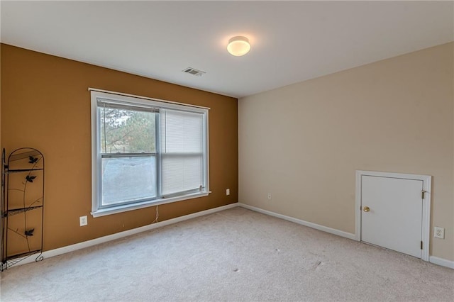 carpeted empty room with visible vents and baseboards