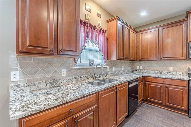 kitchen featuring stainless steel appliances, a center island, sink, and light stone countertops