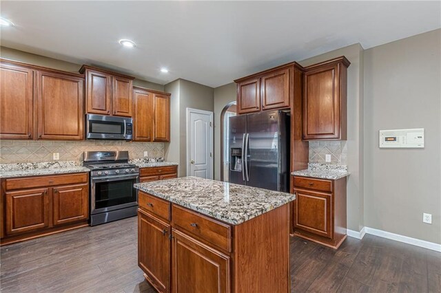 kitchen with dishwasher, ceiling fan, a kitchen island, sink, and tasteful backsplash