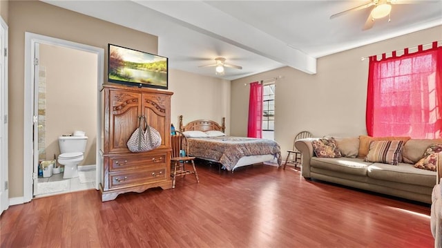 bedroom featuring beam ceiling, ceiling fan, wood finished floors, and ensuite bath