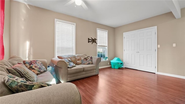living room featuring baseboards, a ceiling fan, and wood finished floors