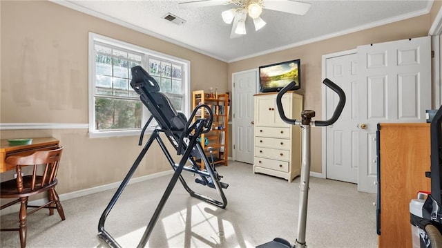 exercise room with crown molding, a textured ceiling, ceiling fan, and light carpet