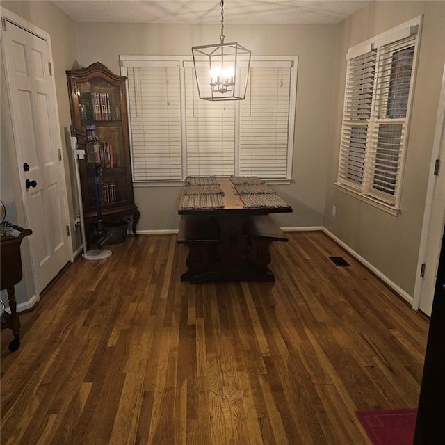 unfurnished dining area with dark hardwood / wood-style floors and a chandelier