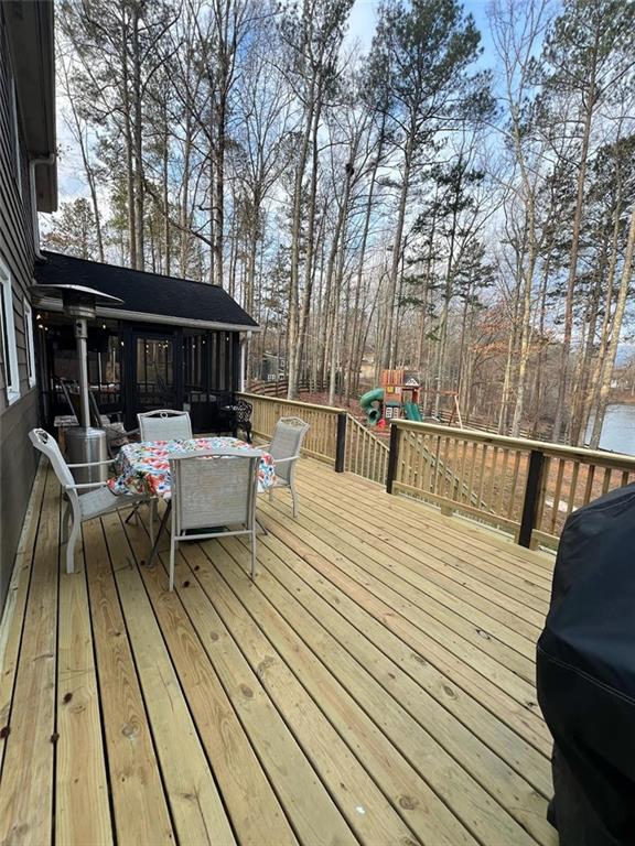 deck with a grill and a playground