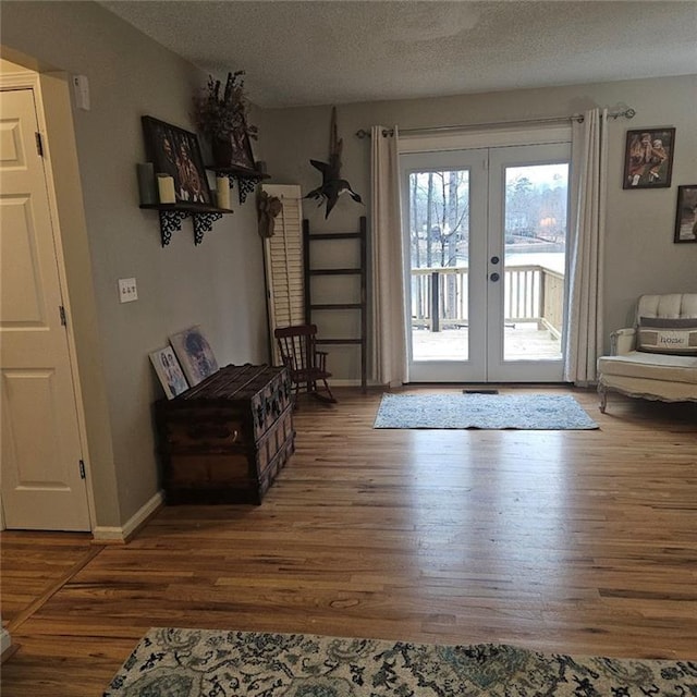 doorway to outside with french doors, dark hardwood / wood-style floors, and a textured ceiling