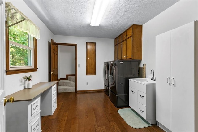 4875 Rivercliff Trce SW, Lilburn, GA 30047 - laundry room with washing machine and clothes dryer, cabinet space, a textured ceiling, and dark wood-type flooring