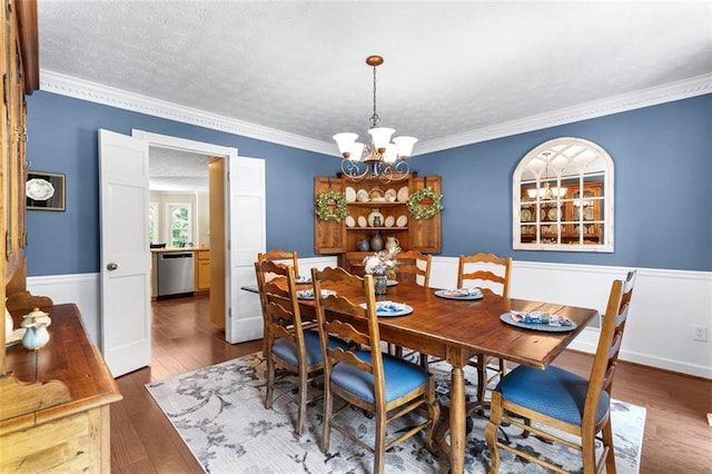 4875 Rivercliff Trce SW, Lilburn, GA 30047 - dining room with a chandelier, wood finished floors, crown molding, a textured ceiling, and wainscoting