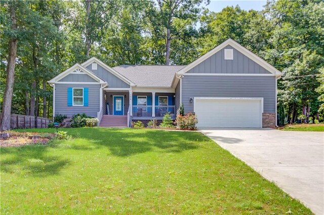 craftsman-style house with a garage, a front yard, and covered porch