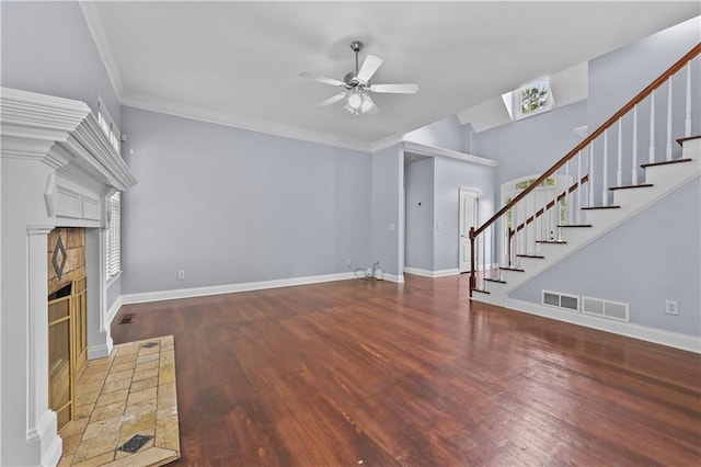 1920 Lee Patrick Dr, Dacula, GA 30019 - unfurnished living room featuring ceiling fan, stairway, wood finished floors, crown molding, and a glass covered fireplace