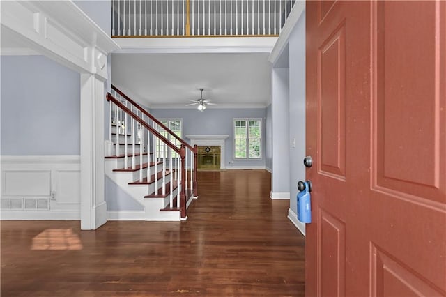 1920 Lee Patrick Dr, Dacula, GA 30019 - entrance foyer featuring a ceiling fan, crown molding, a fireplace, wood finished floors, and stairway