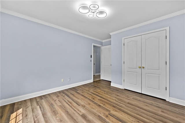 1920 Lee Patrick Dr, Dacula, GA 30019 - unfurnished bedroom with baseboards, wood finished floors, ornamental molding, and a closet