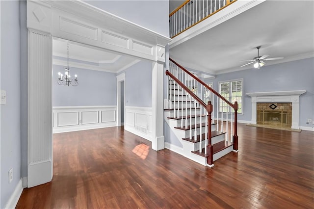 1920 Lee Patrick Dr, Dacula, GA 30019 - stairs featuring a stone fireplace, crown molding, ceiling fan, wood finished floors, and a chandelier