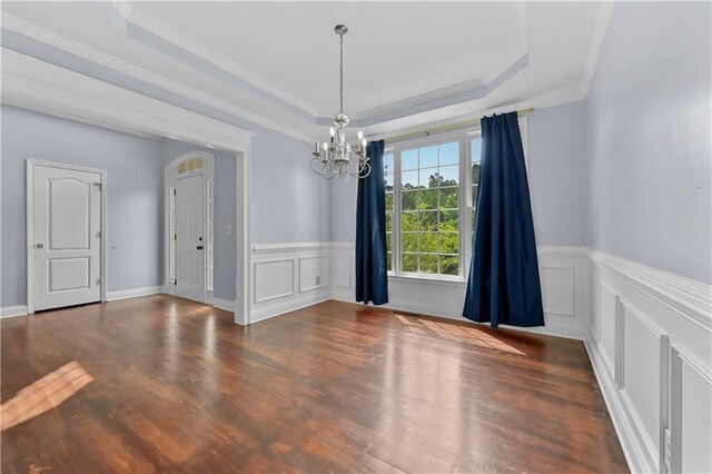1920 Lee Patrick Dr, Dacula, GA 30019 - empty room with a chandelier, a decorative wall, a tray ceiling, wood finished floors, and a wainscoted wall