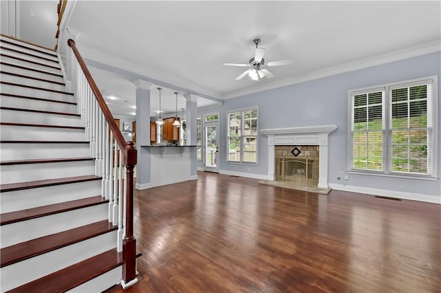 1920 Lee Patrick Dr, Dacula, GA 30019 - unfurnished living room featuring ceiling fan, baseboards, dark wood-style flooring, a fireplace, and crown molding