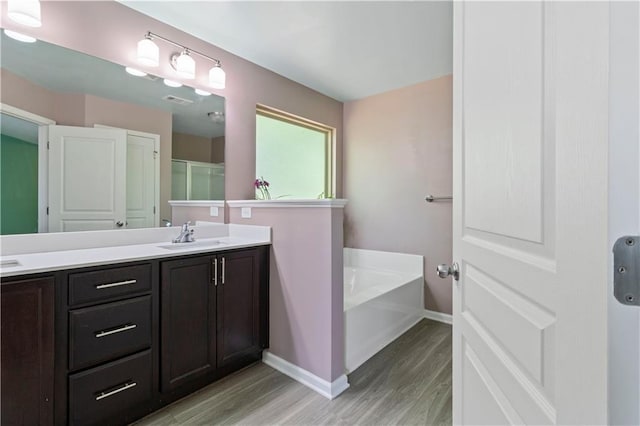 4746 Highland Ave, Sugar Hill, GA 30518 - full bathroom featuring wood finished floors, double vanity, and a garden tub