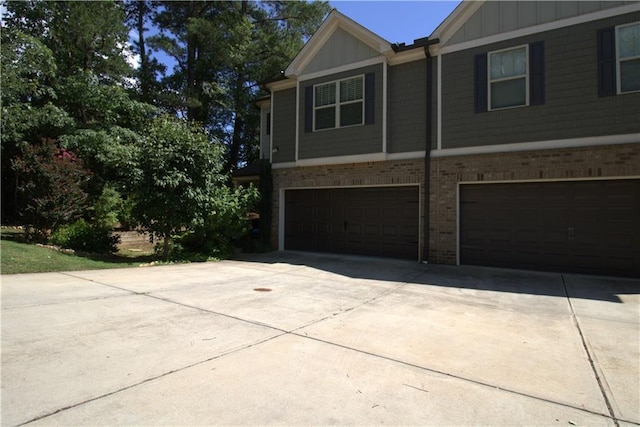 4746 Highland Ave, Sugar Hill, GA 30518 - view of front of home featuring brick siding, an attached garage, driveway, and board and batten siding