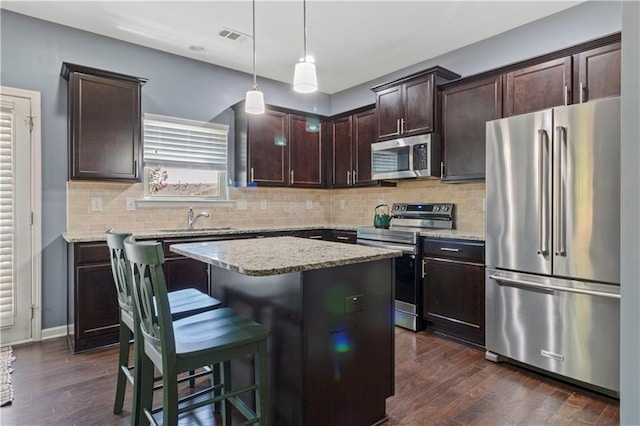 4746 Highland Ave, Sugar Hill, GA 30518 - kitchen with stainless steel appliances, dark brown cabinetry, dark wood-type flooring, backsplash, and light stone counters