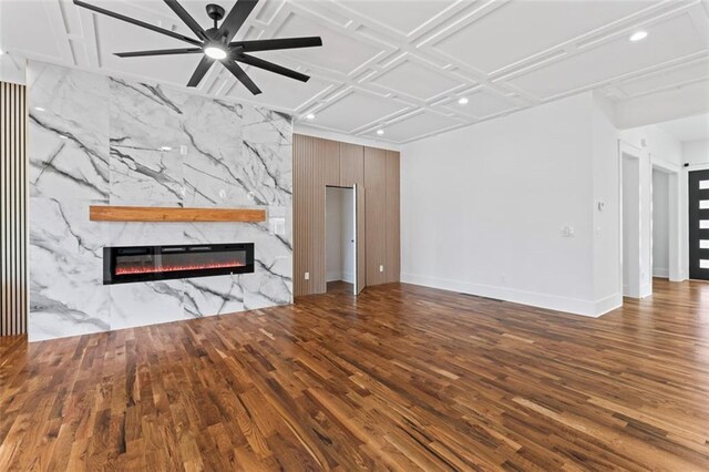 unfurnished living room with a ceiling fan, wood finished floors, a stone fireplace, baseboards, and recessed lighting