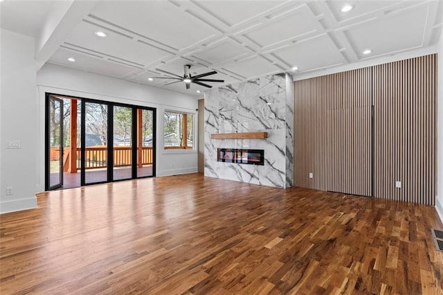 unfurnished living room featuring coffered ceiling, visible vents, a ceiling fan, a fireplace, and wood finished floors