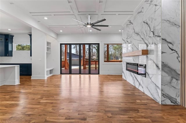 unfurnished living room with a fireplace, wood finished floors, recessed lighting, a ceiling fan, and coffered ceiling