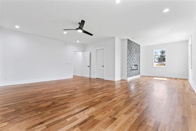 unfurnished living room with baseboards, light wood-type flooring, ceiling fan, and recessed lighting