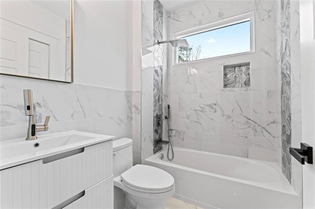full bath with toilet, vanity, tub / shower combination, and tile walls