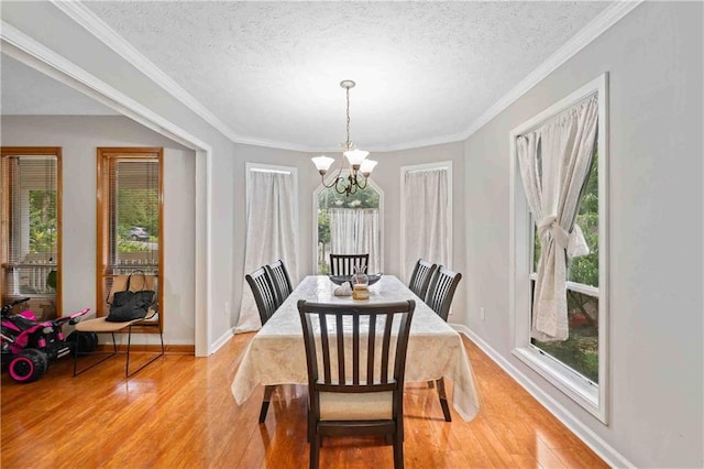 592 Ferry Creek Ct, Acworth, GA 30102 - dining area with a chandelier, light wood-type flooring, healthy amount of natural light, a textured ceiling, and crown molding