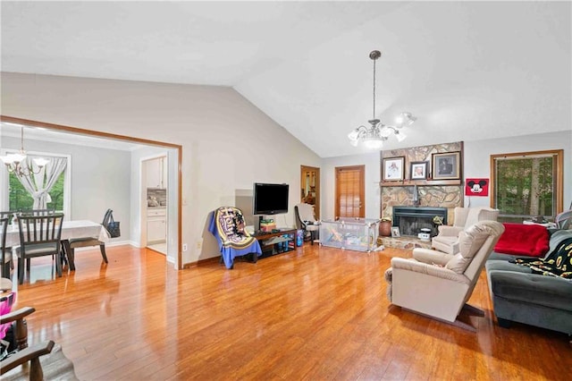 592 Ferry Creek Ct, Acworth, GA 30102 - living area with a chandelier, vaulted ceiling, light wood finished floors, and a stone fireplace