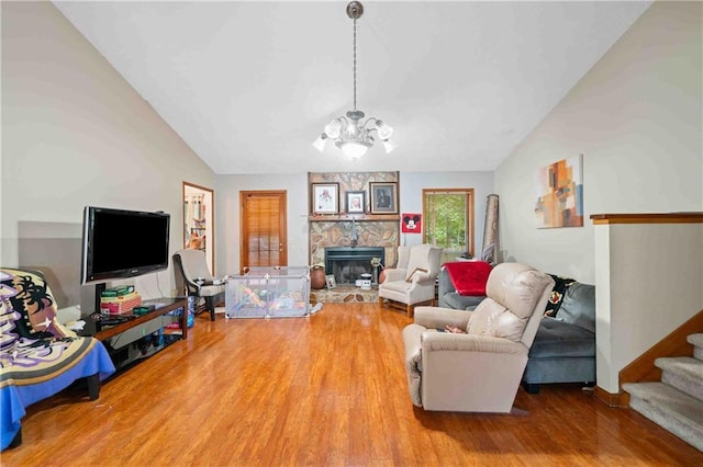 592 Ferry Creek Ct, Acworth, GA 30102 - living area with lofted ceiling, wood finished floors, a chandelier, a fireplace, and stairs