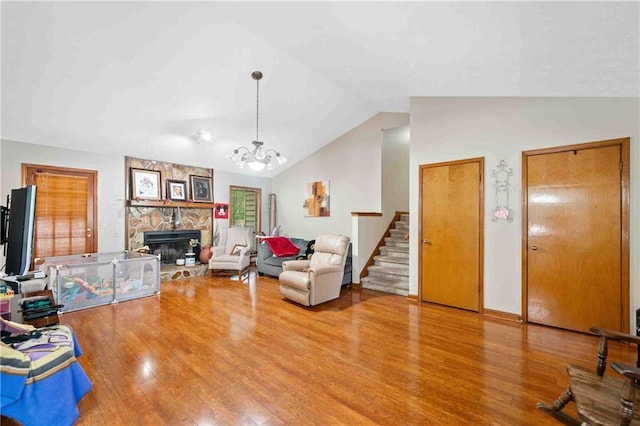 592 Ferry Creek Ct, Acworth, GA 30102 - living room with wood finished floors, stairs, lofted ceiling, a fireplace, and a chandelier