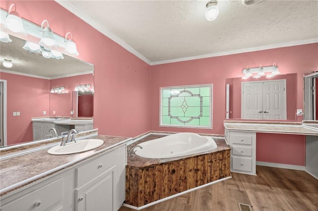 bathroom with vanity, wood-type flooring, a textured ceiling, and ornamental molding