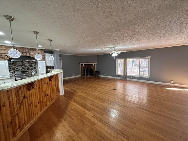 kitchen with ceiling fan, hardwood / wood-style floors, pendant lighting, electric stove, and ornamental molding