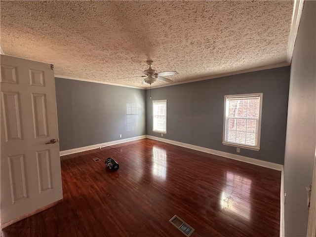 empty room featuring a wealth of natural light, ceiling fan, and dark hardwood / wood-style floors