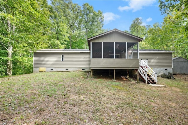 back of house featuring a lawn and a sunroom