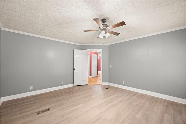 unfurnished room featuring a textured ceiling, light wood-type flooring, and ornamental molding