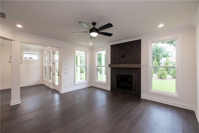 unfurnished living room with ceiling fan, a large fireplace, dark hardwood / wood-style floors, and ornamental molding