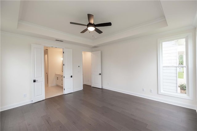 unfurnished bedroom featuring a tray ceiling, multiple windows, ceiling fan, and crown molding