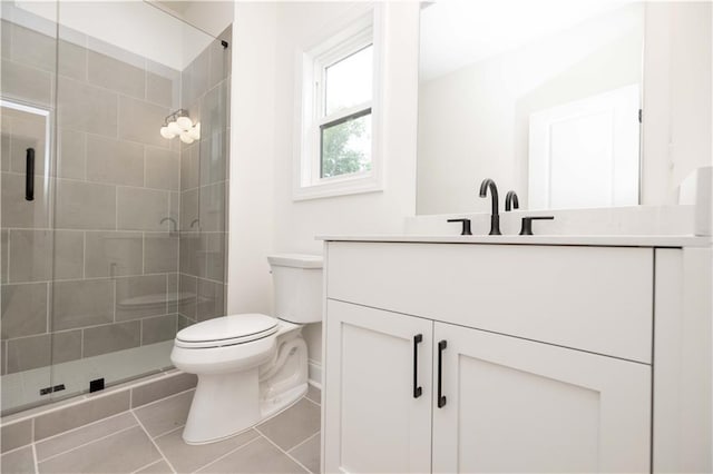 bathroom with toilet, vanity, tile patterned floors, and walk in shower